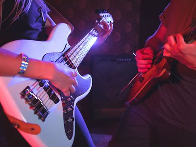 Mid section of male and female guitarist in nightclub